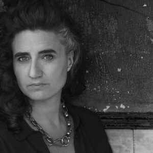 A headshot of Itziar Barrio in front of a grey wall.